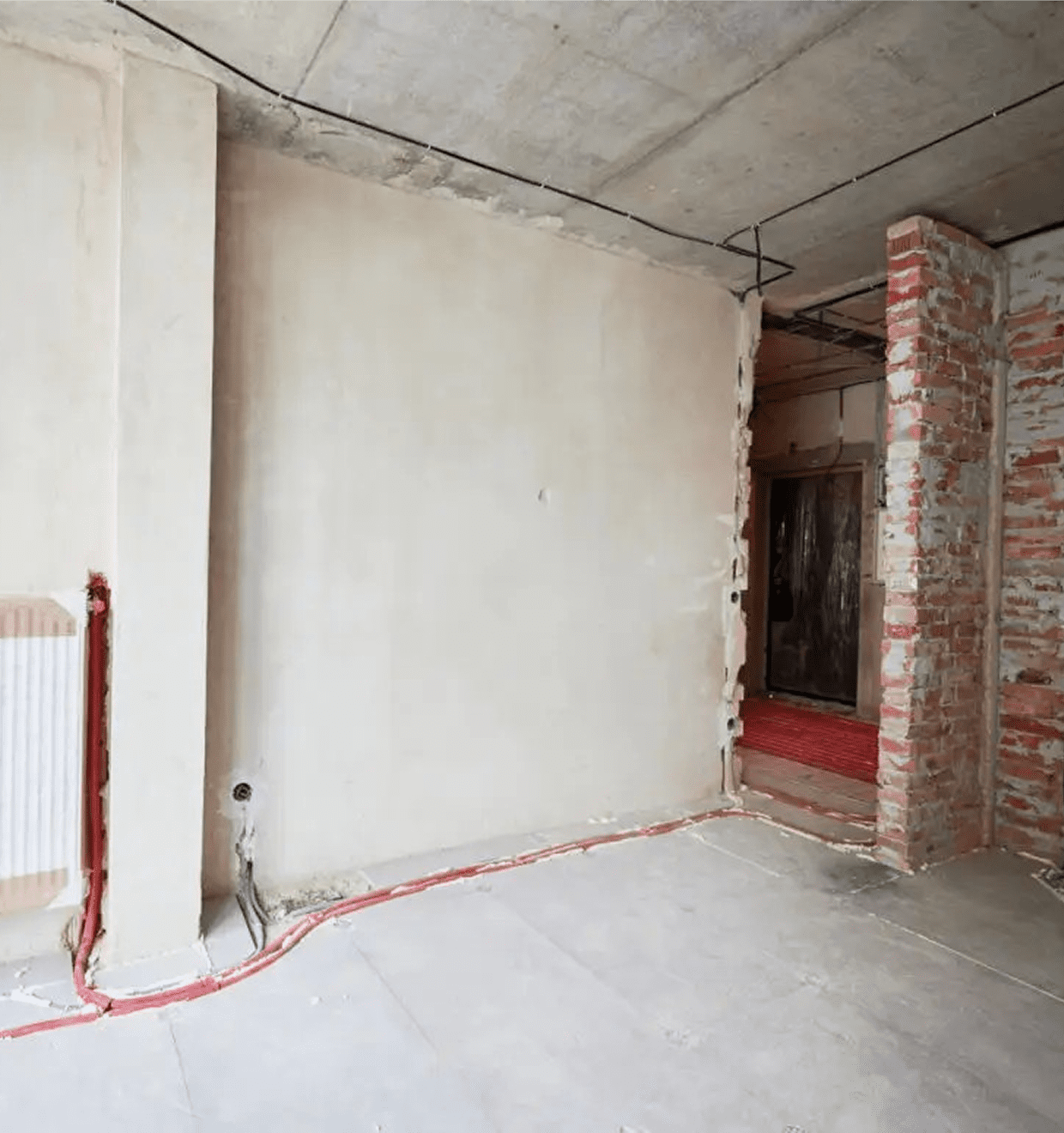 Unfinished room with exposed brick wall